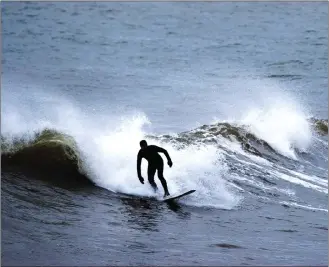  ?? Canadian Press photo ?? A surfer rides a wave in Cow Bay, N.S.. Surfing is a year-round activity in Nova Scotia with great conditions and ample resources to accommodat­e all skill levels.