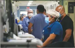  ?? Los Angeles Times/tns ?? Hospital doctors and nurses work treat COVID-19 patients in a makeshift ICU wing at Harbor UCLA Medical Center on Dec. 29 in Torrance.