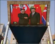  ?? ASSOCIATED PRESS ?? A giant TV screen broadcasts the meeting of North Korean leader Kim Jong Un and Chinese President Xi Jinping during a welcome ceremony in Beijing on Tuesday.