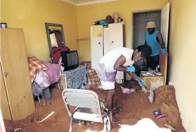  ?? / SANDILE NDLOVU ?? Bongani Letele and Thomas Dzhidzhila help remove the soil that was used to cover four bodies in a house in Vlakfontei­n.