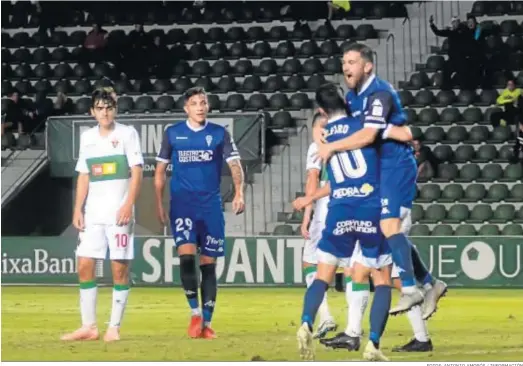  ?? FOTOS: ANTONIO AMORÓS / INFORMACIÓ­N ?? Javi Galán se abraza con Alfaro para celebrar su gol, mientras los jugadores del Elche muestran su desolación.