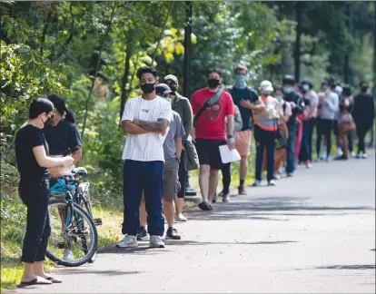  ?? The Daily Courier ?? People wait in line at a COVID-19 testing facility in Burnaby on Aug. 13. A new public opinion study suggests Canadians believe the COVID19 crisis has brought their country together.