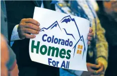  ?? PHOTOS BY DAVID ZALUBOWSKI THE ASSOCIATED PRESS ?? LEFT: Colorado state Sen. Tony Exum Jr. holds a placard during a rally last month to unveil an eviction protection­s bill being advanced by Democratic lawmakers in Denver.