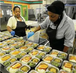  ?? MARSHALL GORBY / STAFF ?? The staff at Miami Valley Meals — Cheryl Robinson (left) and Marilyn Britt — prepare Thanksgivi­ng meals in 2022.