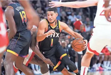  ?? JOE RONDONE/THE REPUBLIC ?? Suns guard Devin Booker (1) weaves through Houston Rockets defenders at Footprint Center on Oct. 30.