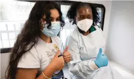  ?? EMILY MICHOT emichot@miamiheral­d.com ?? Jenna Ramkhelawa­n, 12, celebrates with UM Health LPN Delores Fye after Jenna received her first dose of the Pfizer vaccine Tuesday at the Center for Haitian Studies.