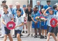  ??  ?? TOKENS OF APPRECIATI­ON: Pupils from St Joseph’s Primary School lay wreaths.