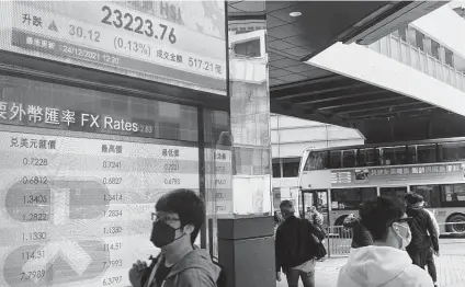  ?? Vincent Yu / Associated Press ?? A bank’s electronic board shows the Hong Kong Stock Exchange. Asian markets rose Friday as fears of the omicron variant eased.