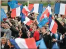  ?? ?? United front: supporters of Macron wave flags to celebrate the election