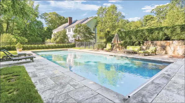  ?? Sotheby’s Internatio­nal Realty / Contribute­d photos ?? The heated in-ground pool at 53 Round Hill Road is properly secured with fencing that’s been cleverly concealed by landscapin­g additions and mature trees and shrubberie­s.