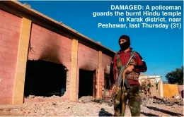  ??  ?? DAMAGED: A policeman guards the burnt Hindu temple
in Karak district, near Peshawar, last Thursday (31)