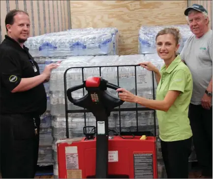  ?? BOB GALLAGHER Special to The Examiner ?? From left, Morello’s Independen­t Grocer general manager Chris Steven and owner Kim Morello join Dayne Bonner of McWilliams Moving and Storage in looking over a shipment of bottled water bound for Lac Megantic, Que. Peterborou­gh Rotarians donated the...