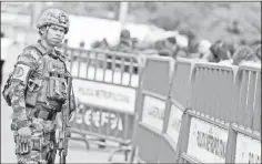  ??  ?? A Colombian army member observes the passage of people on the Simon Bolivar internatio­nal bridge, after a shooting near to the border between Colombia and Venezuela, in Cucuta. — Reuters photo