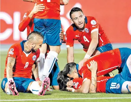  ?? AP ?? Una fiesta. Alexis Sánchez acaba de anotar el segundo gol y se abraza con Valdivia. Arturo Vidal los mira.
