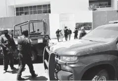  ??  ?? La fémina y otro joven son escoltados por policías y militares al llegar al edificio de la FGR.