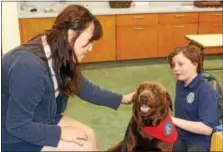  ?? MICHILEA PATTERSON — DIGITAL FIRST MEDIA ?? Coventry Christian Schools students Soo Kim, 18, and 12-year-old Maggie Thompson, on the right, spend some time with a visiting pet therapy dog during a mental health awareness education activity at the school.