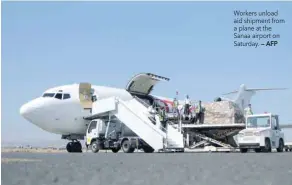  ?? — AFP ?? Workers unload aid shipment from a plane at the Sanaa airport on Saturday.