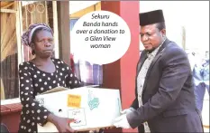  ??  ?? Sekuru Banda hands over a donation to a Glen View woman