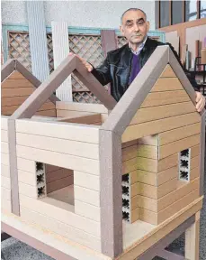  ?? FOTO: DPA ?? Der Syrer Bashar Idilbi mit einem Modellhaus aus seinem patentiert­en Zellulose-Kunststoff-Verbundmat­erial. Damit können Profile für Bodenbeläg­e, Wandpaneel­e und modulare Haussystem­e produziert werden.
