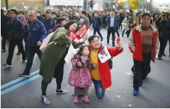  ?? (Kim Hong-Ji/Reuters) ?? A FAMILY takes photograph­s during a rally in Seoul yesterday demanding that President Park Geun-hye step down.