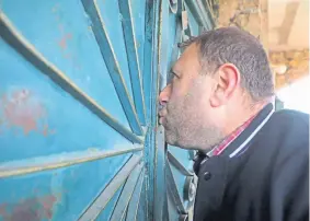  ??  ?? Syrian Saleh al-Sheikh kisses the gate of his house as he prepares to flee the regime’s recent offensive in Idlib.