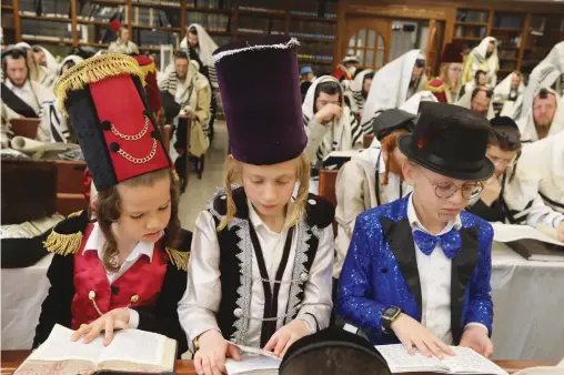  ?? (Photos: Flash90) ?? ULTRA-ORTHODOX CHILDREN follow a Scroll of Esther reading in Beit Shemesh last month. One might wonder how a nation so internally fragmented can possibly hold together, says the writer.