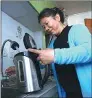  ?? XING GUANGLI / XINHUA ?? A Beijing resident prepares to boil water. The tap water in her home originates from the
South-to-North Water Diversion Project.