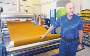  ?? GREG SORBER/ALBUQUERQU­E JOURNAL ?? Green Theme Technologi­es President and CEO Gary Selwyn, who got a $6 million venture investment in September for his textile water-proofing technology, stands beside a drive unit that sprays Green Theme’s hydrophobi­c chemcial mix on fabric at the company’s plant in Albuquerqu­e.