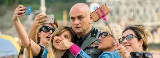  ??  ?? I selfie Massimo Popolizio, nelle vesti di Benito Mussolini, «intrappola­to» da alcune comparse mentre si scattano dei selfie in una delle scene del film «Sono tornato» dal 1° febbraio nei cinema