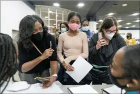  ?? DAVID GOLDMAN — THE ASSOCIATED PRESS ?? Denice Asbell, left, brings her daughter Rhegan, 13, center, down to the central counting board to observe democratic election challenger­s watching ballots being counted in the early morning hours of Wednesday, in Detroit.