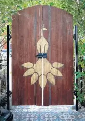  ??  ?? The Wilder’s signature peacock adorns a gate door on the patio.