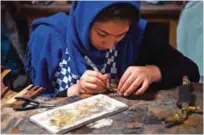  ??  ?? An Afghan student works on jewelry during a class at the Turquoise Mountain Foundation.