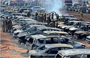  ?? Reuters ?? Firefighte­rs extinguish smoulderin­g cars after a fire broke out in a parking lot during the aero india show at the Yelahanka air Force Station in Bengaluru on Saturday. —