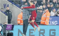  ??  ?? HEART-TO-HEART: Liverpool forward Roberto Firmino, right, celebrates his goal against Leicester with manager Juergen Klopp.