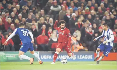  ?? — Gambar AFP ?? TIDAK BERI RUANG: Salah (tengah) dikawal ketat oleh dua pemain pertahanan Porto ketika beraksi pada perlawanan di Anfield, Liverpool pada Selasa lepas.