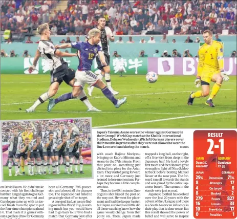  ?? ?? Japan's Takuma Asano scores the winner against Germany in their Group E World Cup match at the Khalifa Internatio­nal Stadium, Doha on Wednesday. (Pic left) German players cover their mouths in protest after they were not allowed to wear the One Love armband during the match.