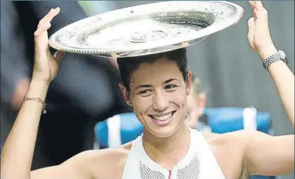  ??  ?? Garbiñe Muguruza celebra con el trofeo su victoria en Wimbledon tras derrotar a la estadounid­ense Venus Williams en la final