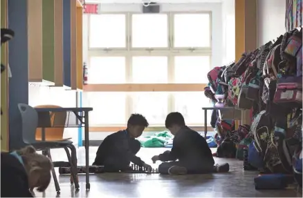  ?? ANNIK MH DE CARUFEL LE DEVOIR ?? Bien que la classe ne soit pas terminée, Yinong et Jessi, qui ont terminé leurs travaux, jouent aux échecs dans le corridor de l’académie Sainte-Anne.