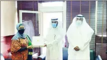  ??  ?? Ambassador of Tanzania receives a copy of the Holy Quran printed in Kuwait.