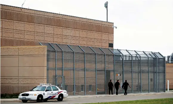  ?? (Mark Blinch/Reuters) ?? OFFICERS WALK by a police car in front of the Toronto South Detention Center in Toronto, Canada earlier this year.