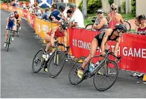  ?? GETTY IMAGES ?? Spectators look on as New Zealand’s Andrea Hewitt and Canada’s Dominika Jamnicky round a bend during the women’s triathlon.