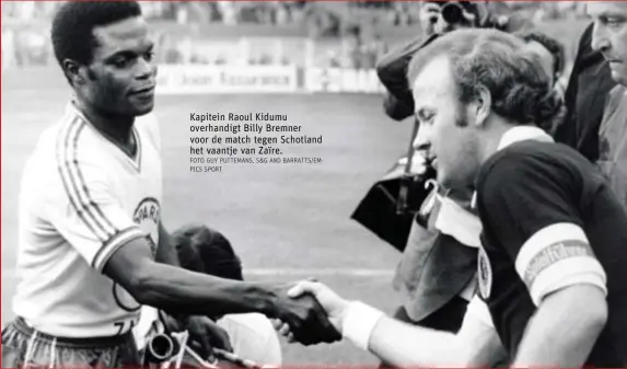  ?? FOTO GUY PUTTEMANS, S&G AND BARRATTS/EMPICS SPORT ?? Kapitein Raoul Kidumu overhandig­t Billy Bremner voor de match tegen Schotland het vaantje van Zaïre.