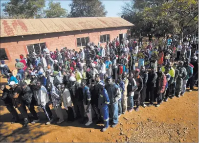  ?? Jerome Delay ?? Zimbabwean­s stand in line as they wait to vote Monday at Sherwood Primary School in Kwekwe, Zimbabwe. The Associated Press