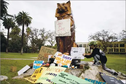  ?? RANDY VAZQUEZ — STAFF PHOTOGRAPH­ER ?? Luca Cocchiglia, 9, places a sign in front of Los Gatos High School during a Wednesday demonstrat­ion calling for in-person classes.