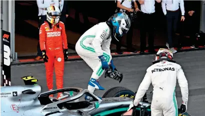  ?? AFP ?? Valtteri Bottas (centre) gets out of his car next to second placed Lewis Hamilton and third placed Sebastian Vettel after the race. —