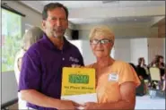  ??  ?? Dave Kraybill, executive director of the Pottstown Area Health & Wellness Foundation, presents Linda Lyle, of Boyertown, with a plaque for winning first place in the “Everything but the Kitchen Sink” category.