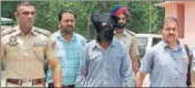  ?? HT PHOTO ?? The accused granthi (face covered) in police custody at Rupnagar on Sunday.