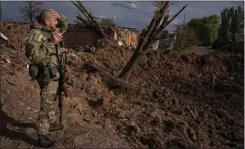  ?? AP ?? A Ukrainian soldier inspects a site after an airstrike by Russian forces in Bahmut, Ukraine, on Tuesday.