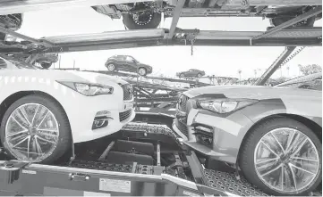  ?? — WPBloomber­g photo ?? Nissan vehicles are loaded onto car carriers for dealer delivery at the Port of Los Angeles in Los Angeles on June 28, 2013.