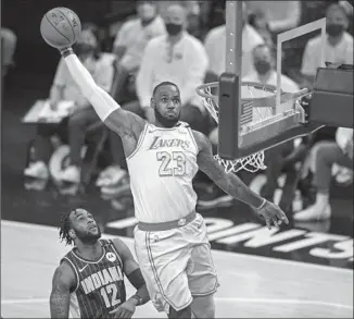  ?? Doug McSchooler Associated Press ?? LEBRON JAMES, who had missed the previous six games with an ankle injury, elevates to dunk the ball in the first half of the Lakers’ 122-115 victory over the Pacers on Saturday in Indianapol­is.